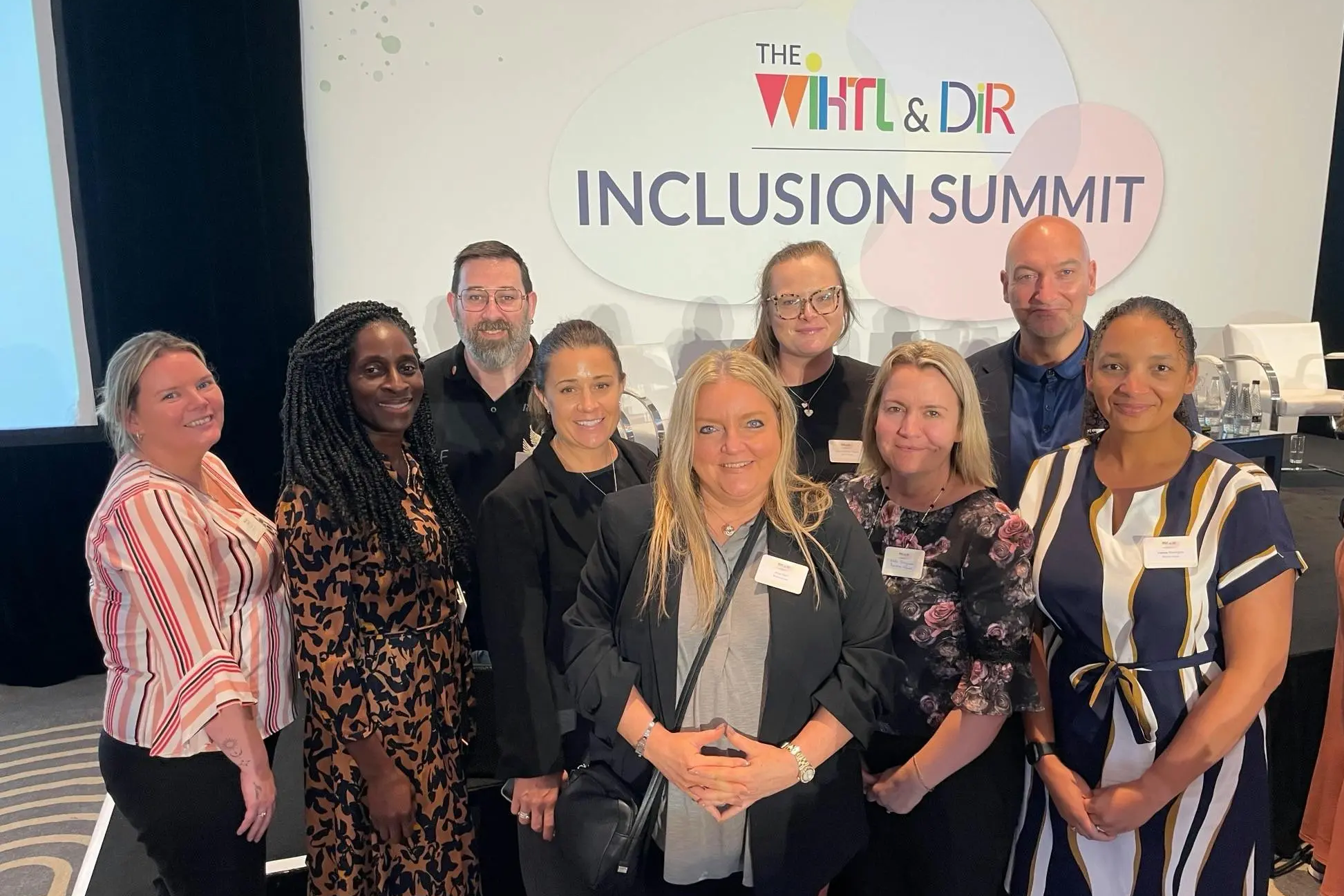 A group of diverse professionals pose together at The Inclusion Summit.