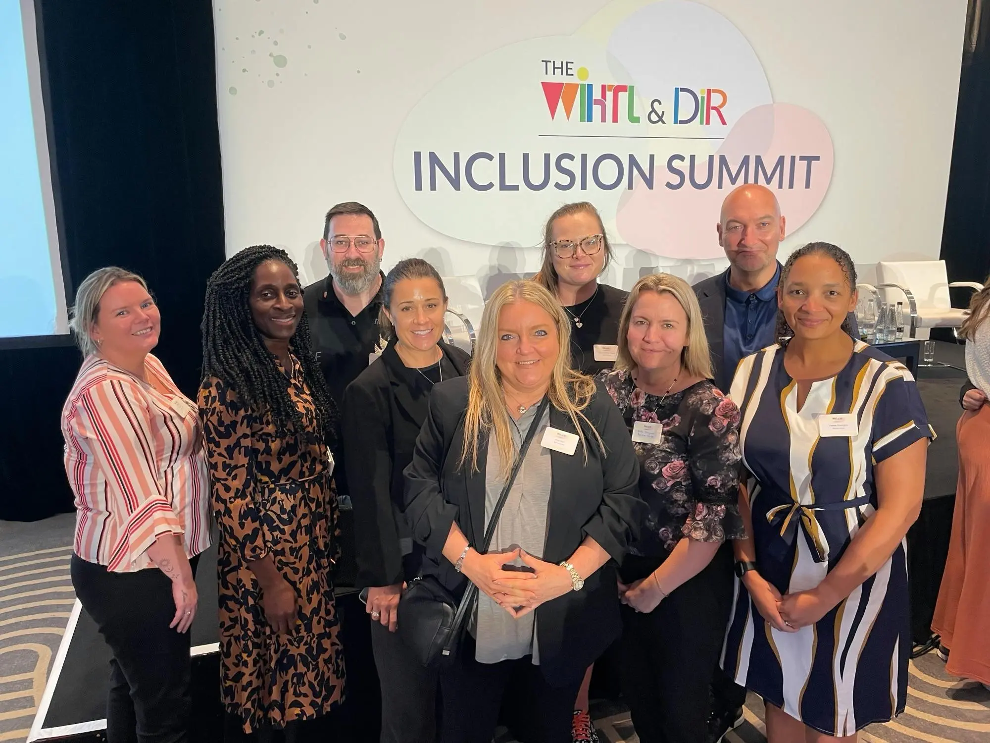 A diverse group of attendees posing together at The Inclusion Summit.