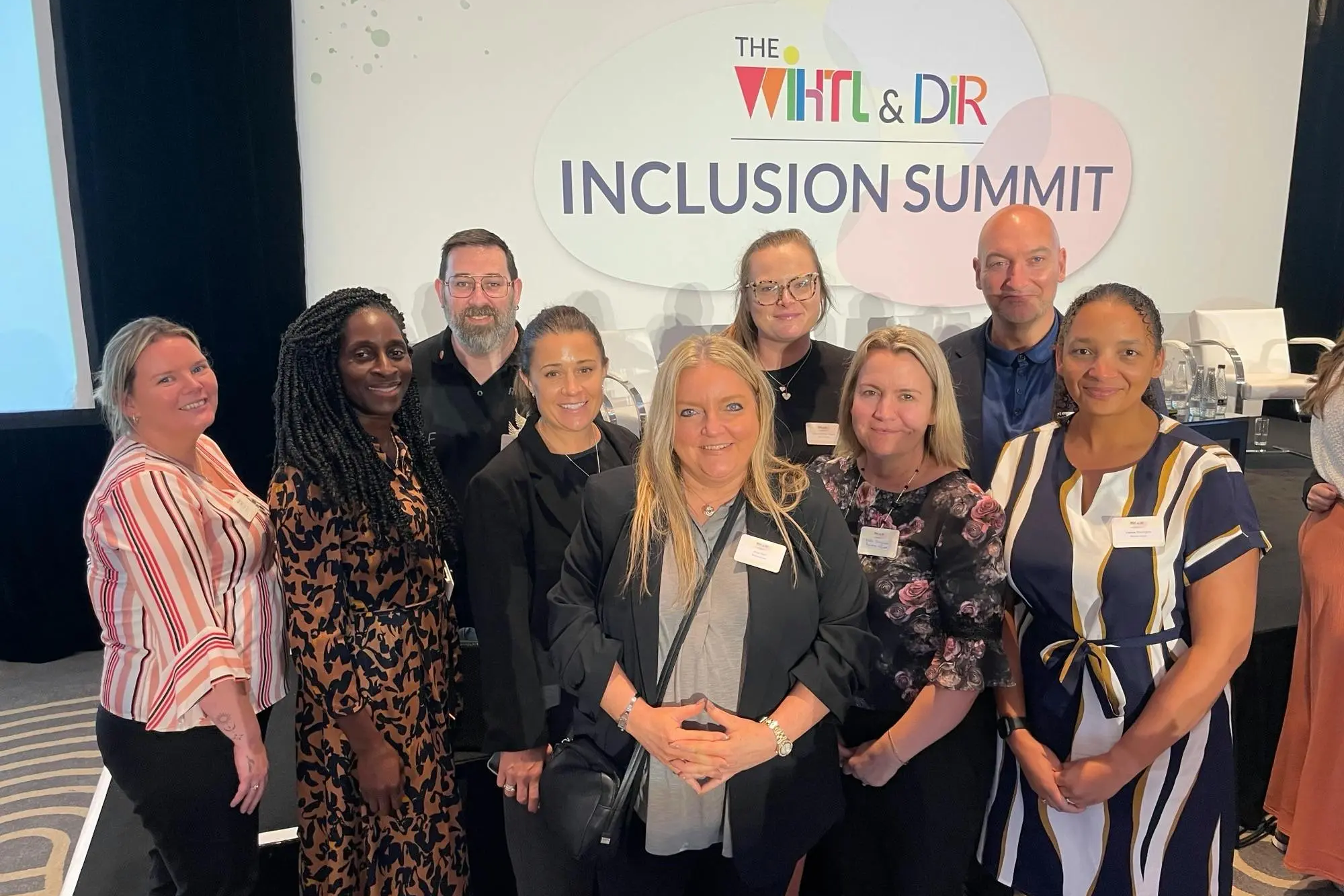 A diverse group of attendees posing together at The Inclusion Summit.