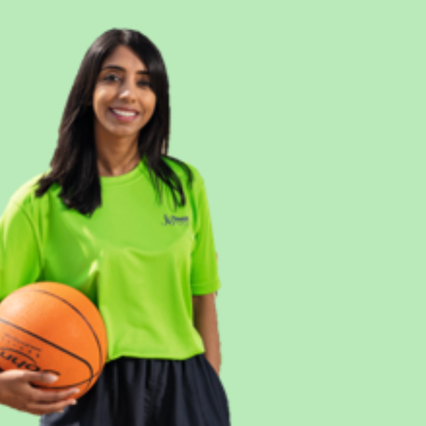 A smiling woman wearing a lime green t-shirt holding a basketball against a light green background.